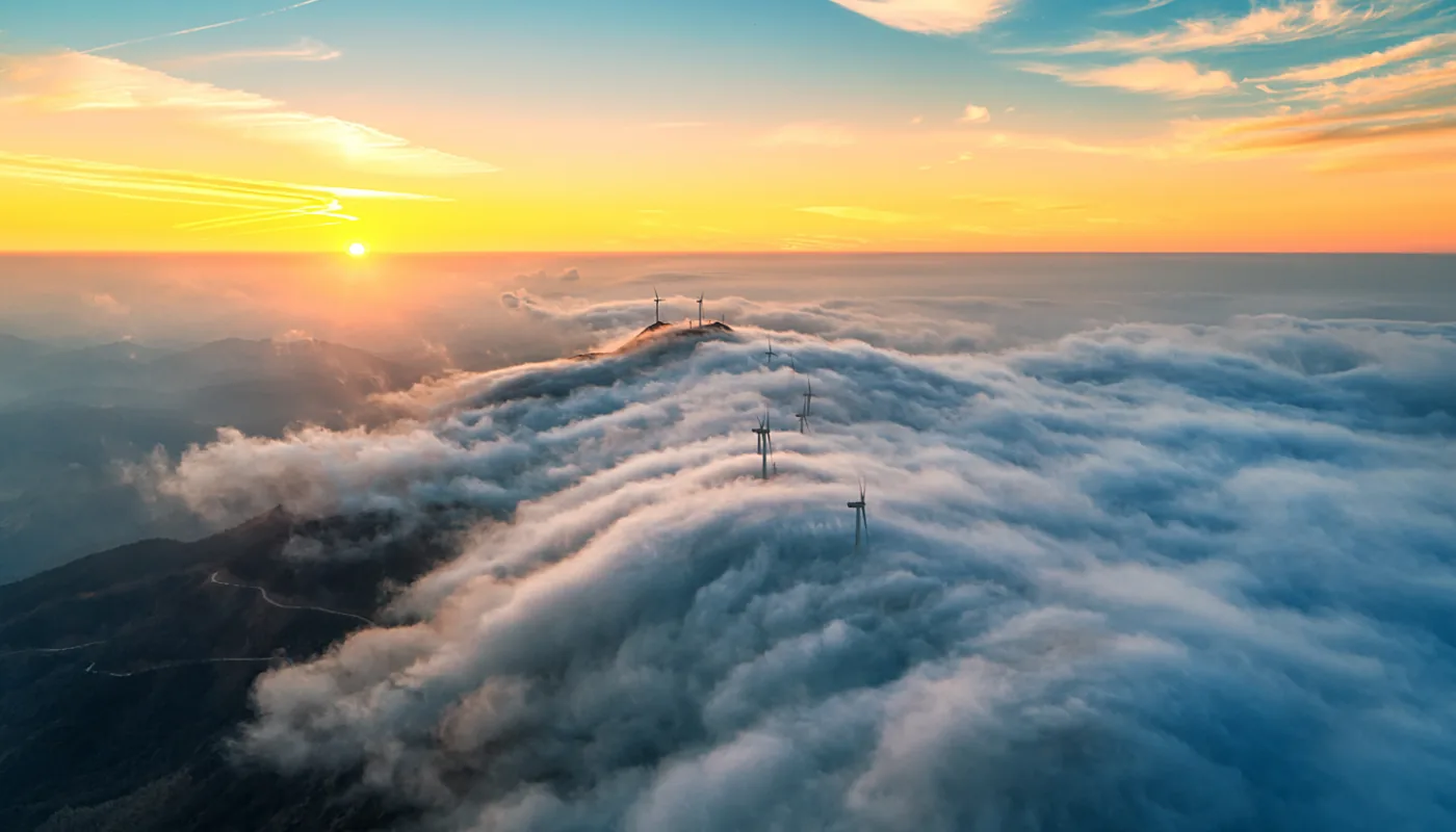 Freileitungsmasten über einer Wolkendecke