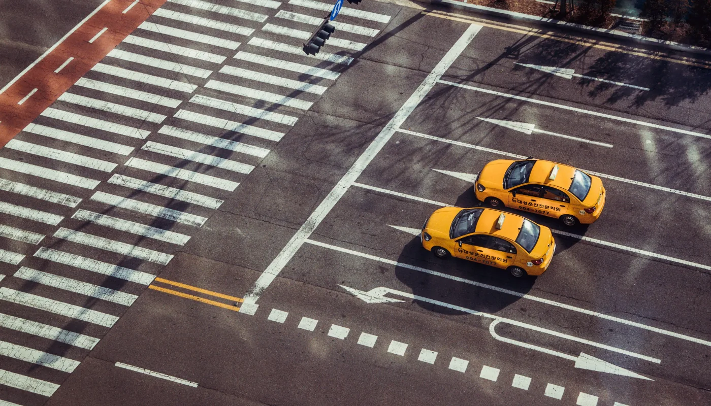 Kreuzung mit Zebrastreifen und Taxis, von oben